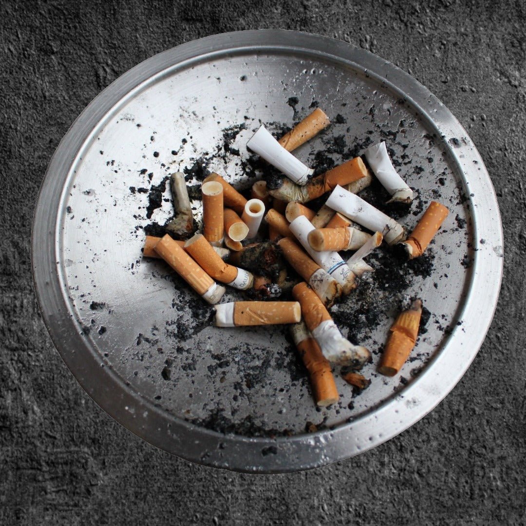 Un cendrier remplis de mégots de cigarettes