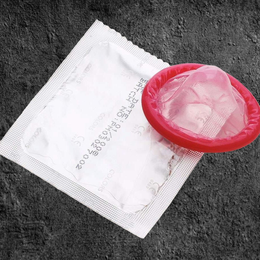 Préservatif avec un couvercle rouge, accompagné d'un sac en plastique transparent, prêt à être utilisé en toute sécurité.