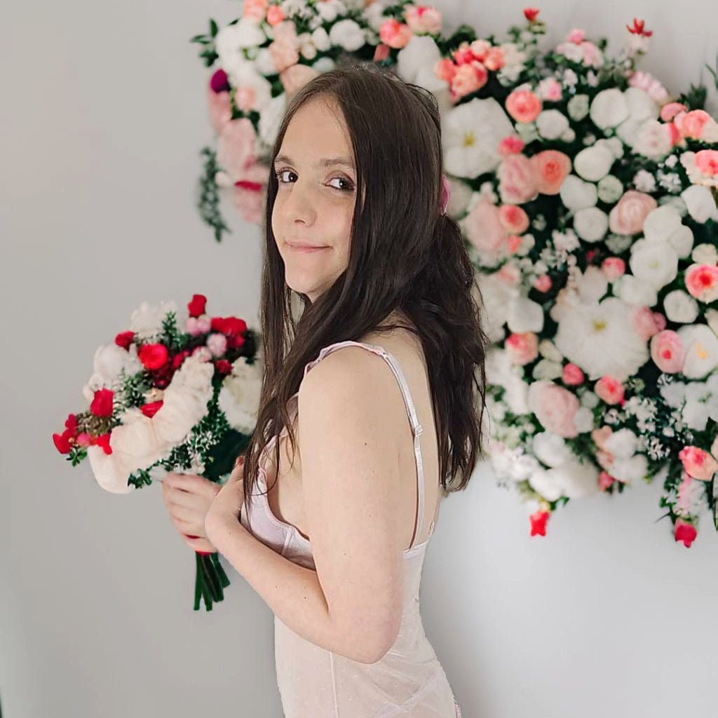 Une jeune fille tiens un bouquet de fleurs dans ces mains